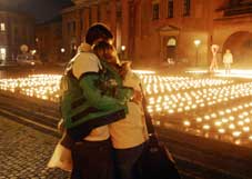 A couple stands in front of a display of 2,000 candles lighted in memory of the victims of HIV/AIDS in Copenhagen, Denmark, on World AIDS Day